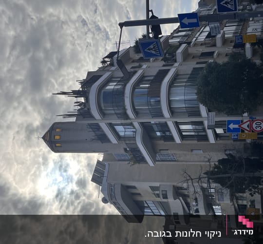 בניין גבוה עם חלונות גדולים ושלטי תנועה